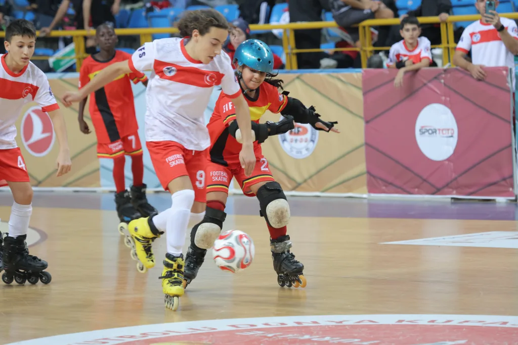 School-age players competing for the ball on inline skates during an international junior match